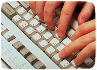 Na zdjęciu widać palce rąk w trakcie pisania na klawiaturze komputerowej.
